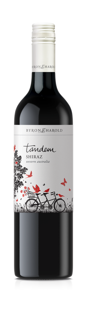A Shiraz bottle from Western Australia with a white cap and a white label with an illustration of a Tandem bike with red birds and butterflies for Byron & Harold wines.