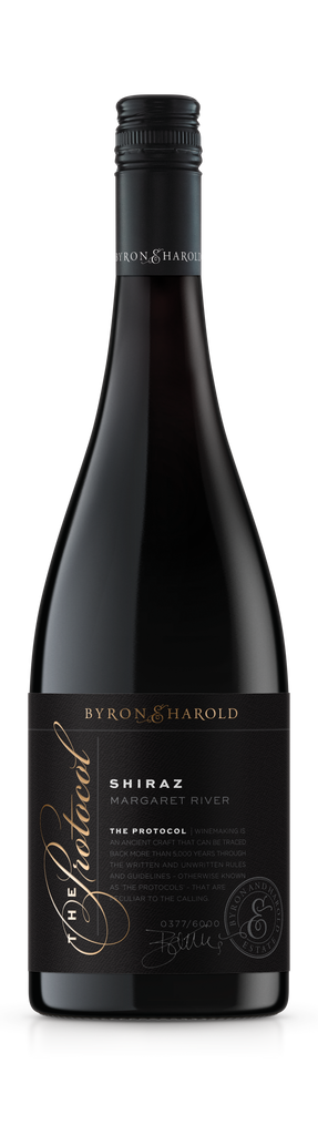A Shiraz bottle from Margaret River with a black cap and black label with a beautiful cursive writing of The Protocol in gold for Byron & Harold wines.